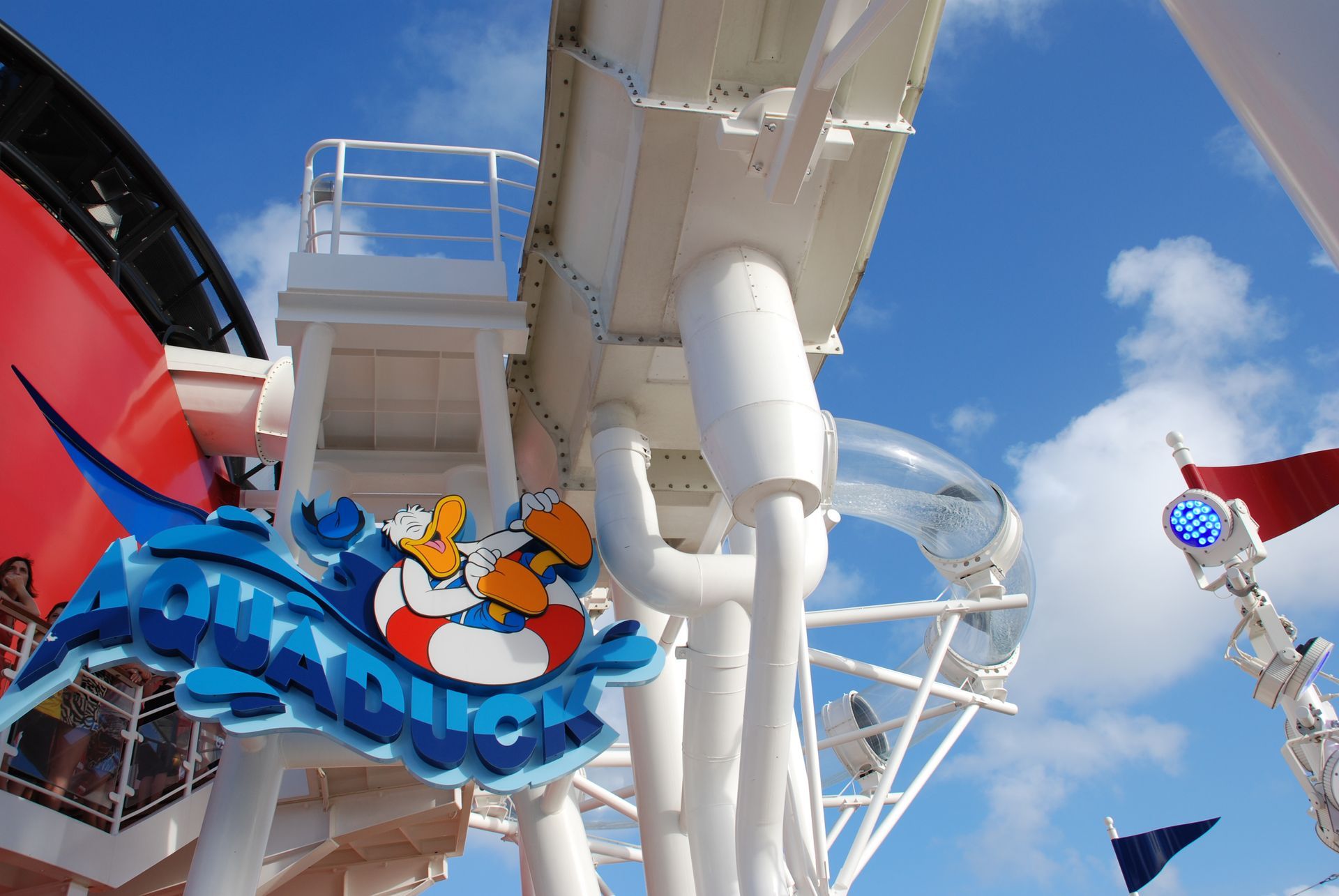 Colorful roller coaster car on a white track against a bright blue sky at an amusement park