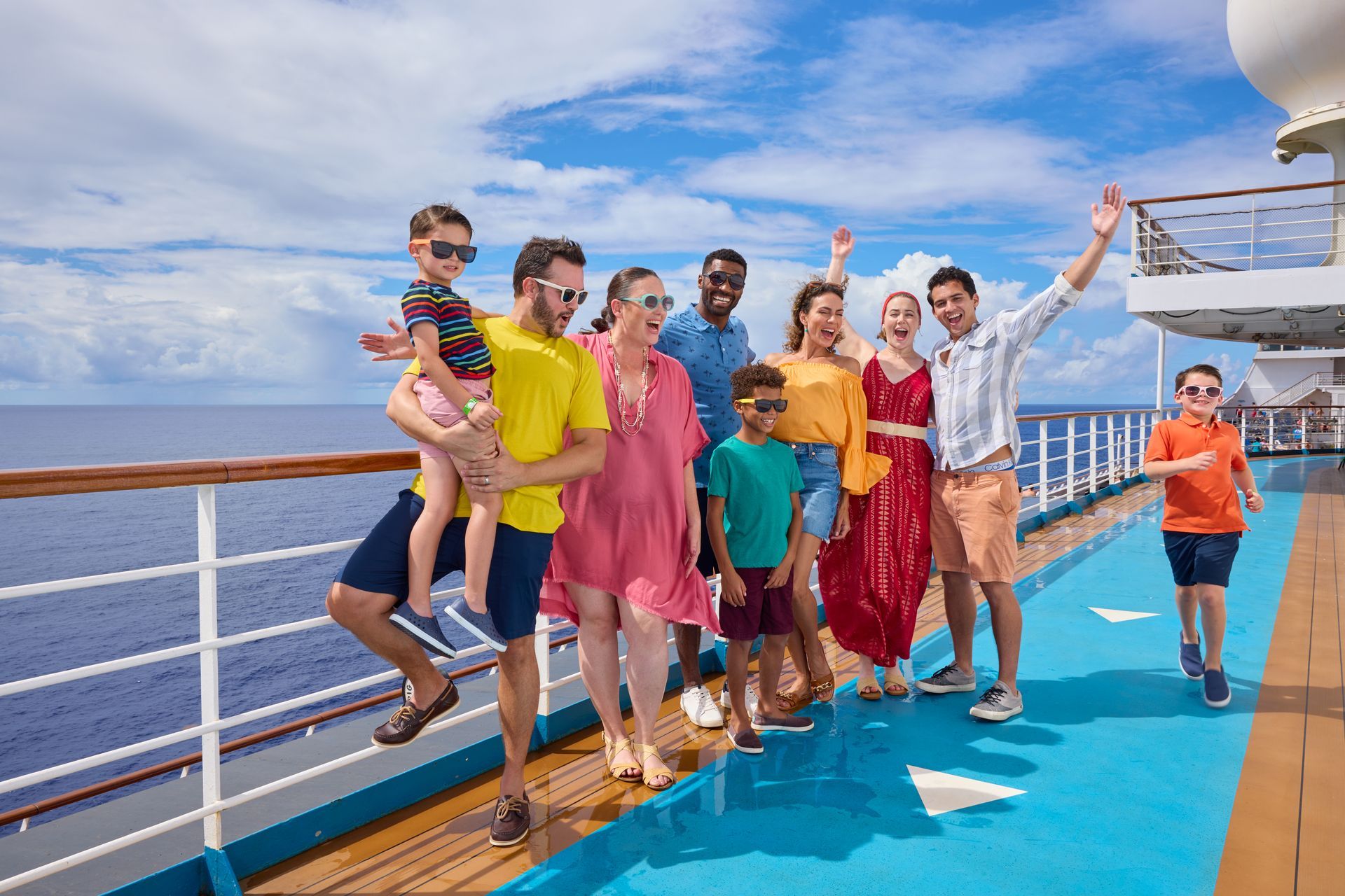 People posing and dancing on a cruise ship deck under a bright blue sky