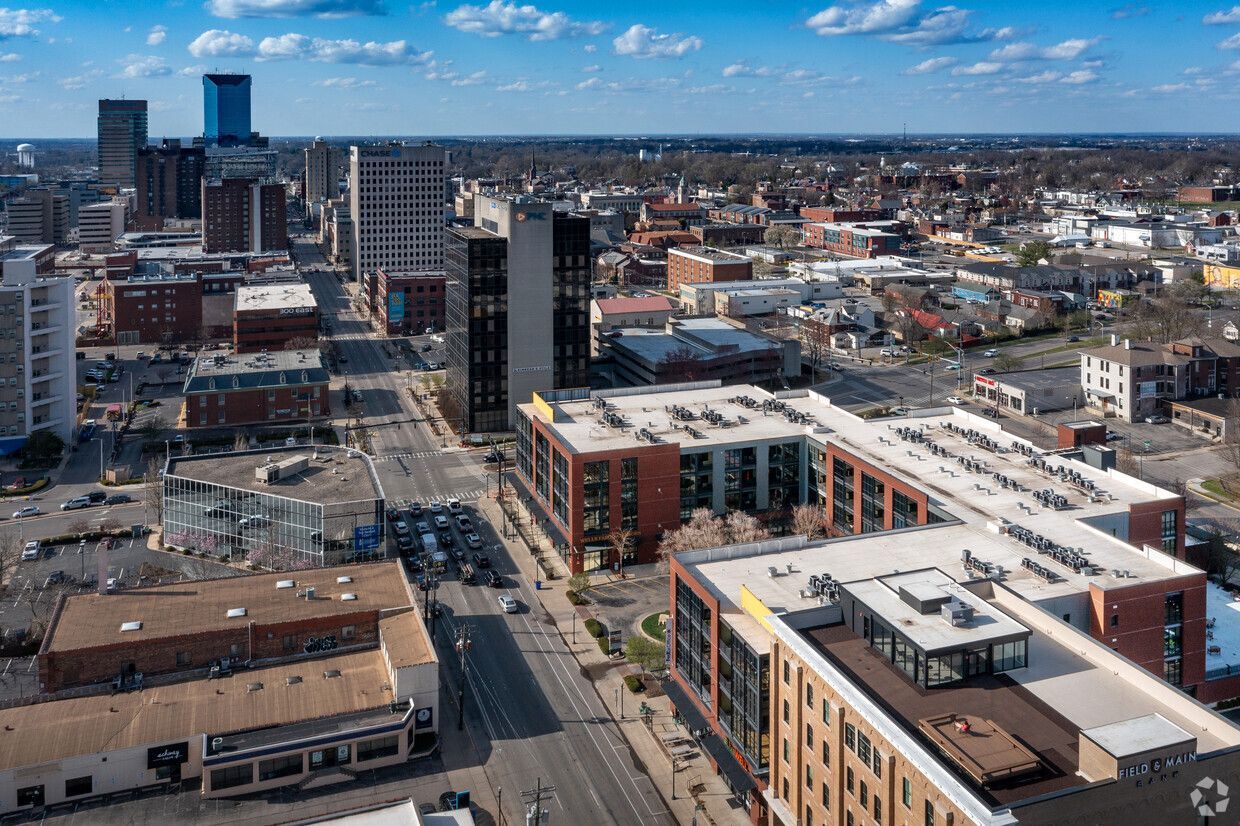 Aerial view of a city skyline with streets, apartment buildings, and a snowy rooftop in winter