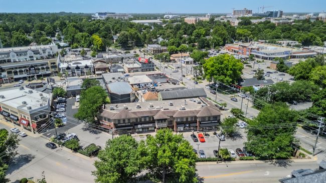 Aerial view of a busy urban neighborhood with low-rise buildings, trees, and intersecting streets.