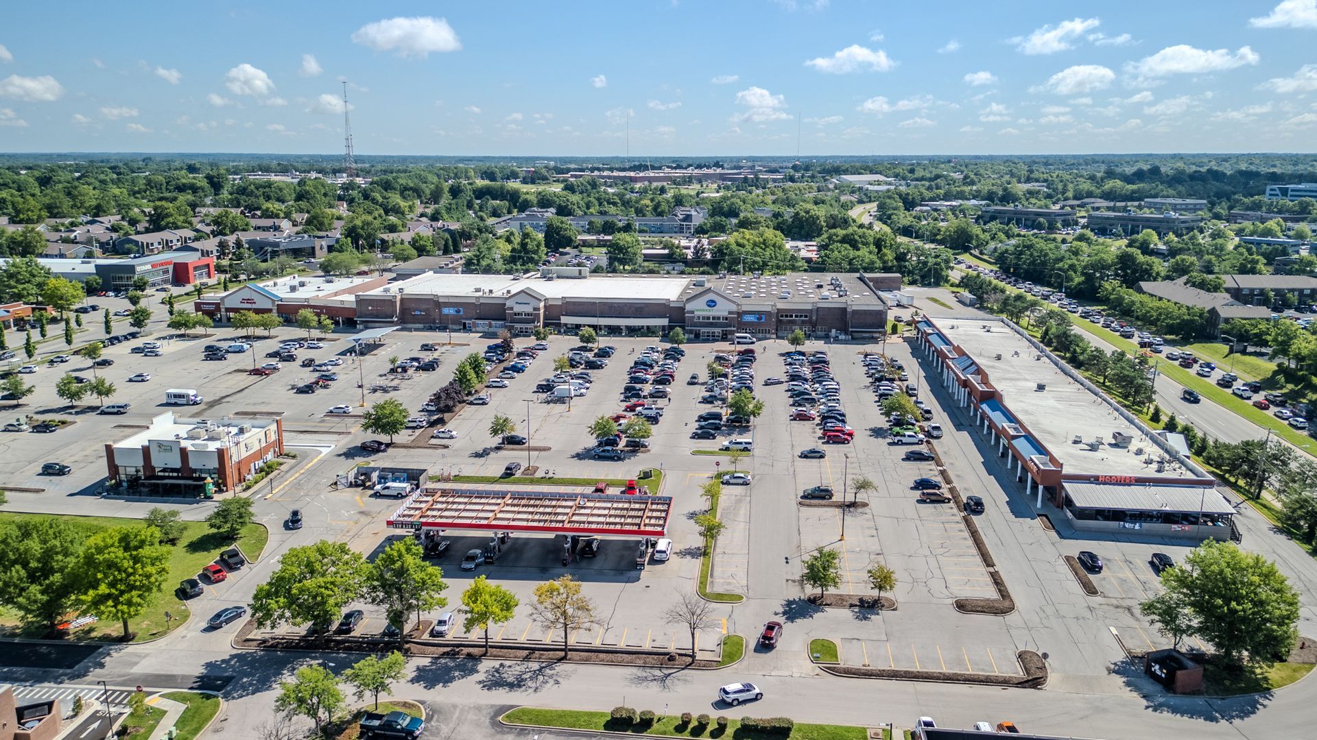 Aerial view of a large parking lot and shopping center on a sunny day