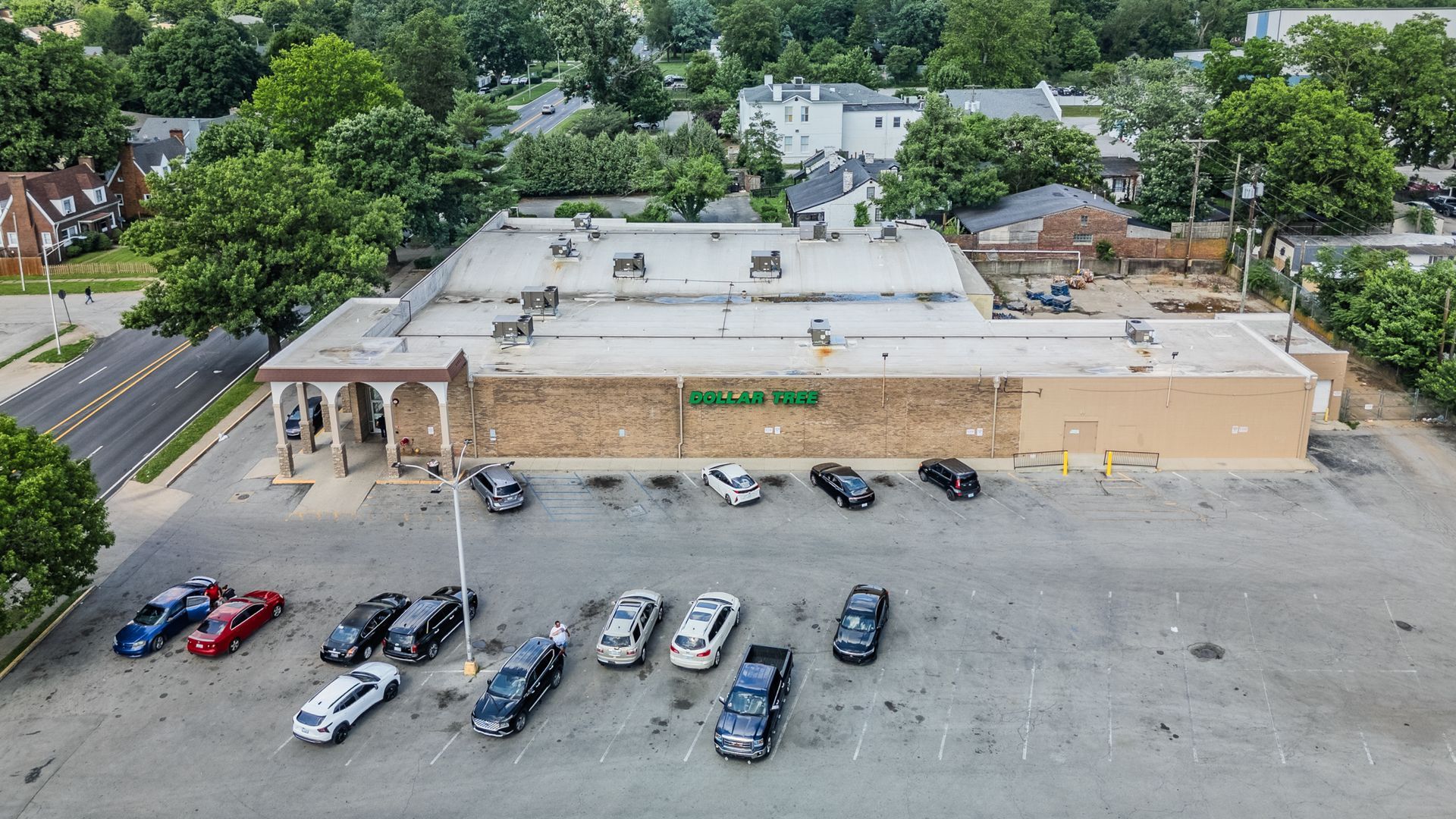 Strip mall with retail storefronts and parking lot on a cloudy day