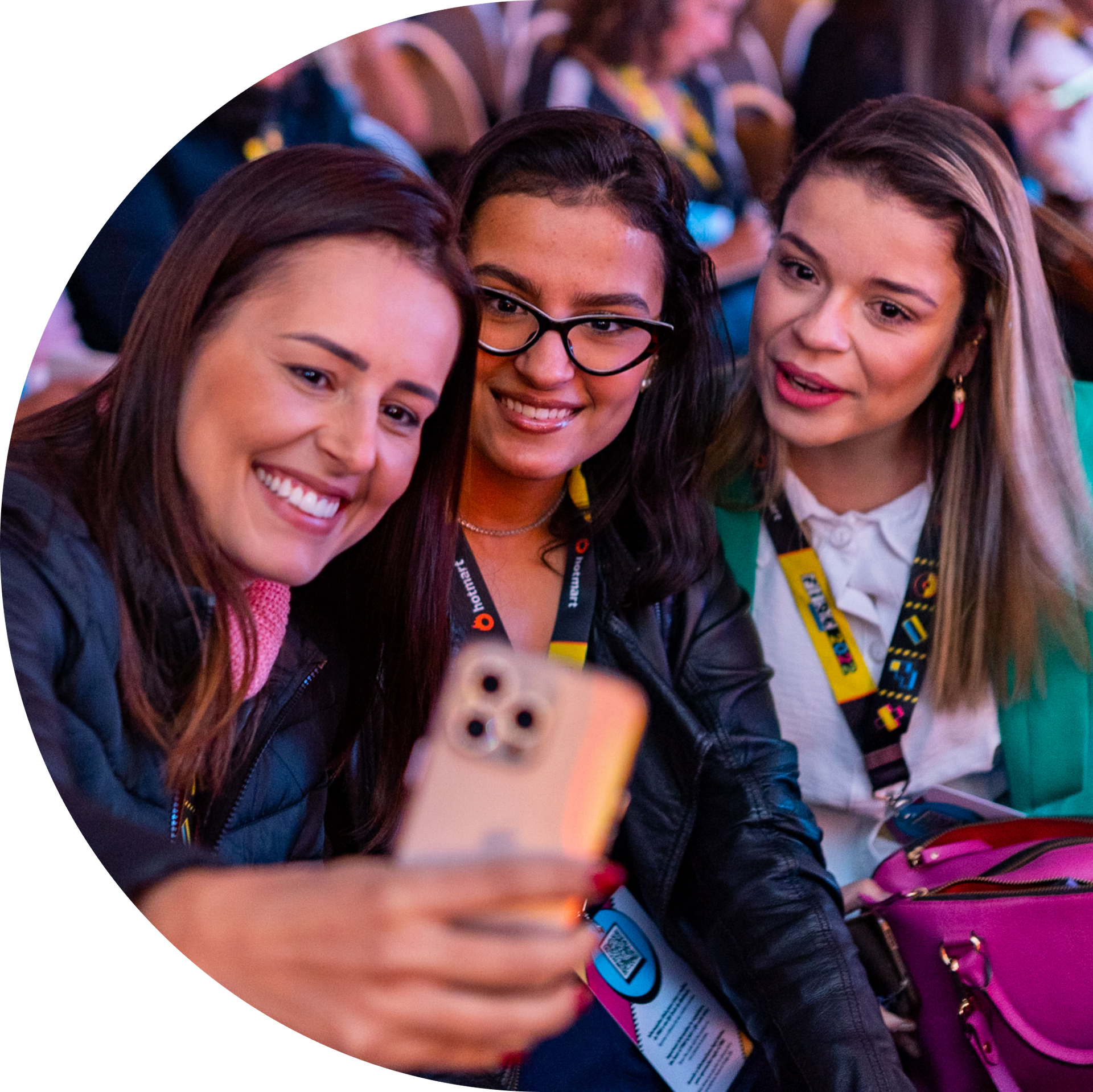 Três mulheres estão tirando uma selfie com um celular.