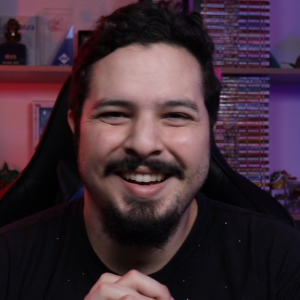 Um homem com barba está sorrindo e vestindo uma camisa preta