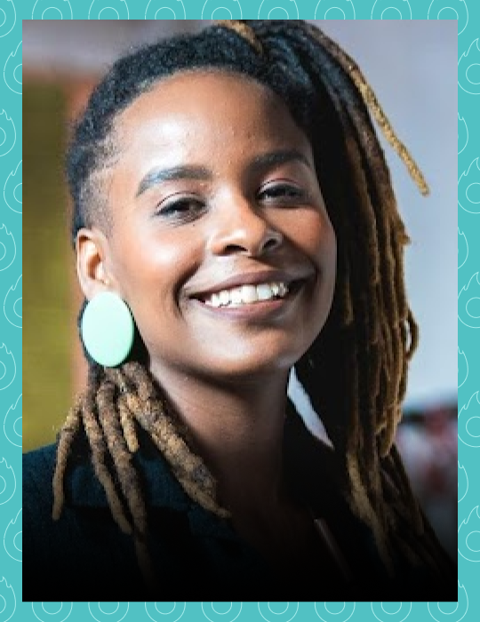 Uma mulher com dreadlocks e brincos está sorrindo para a câmera.