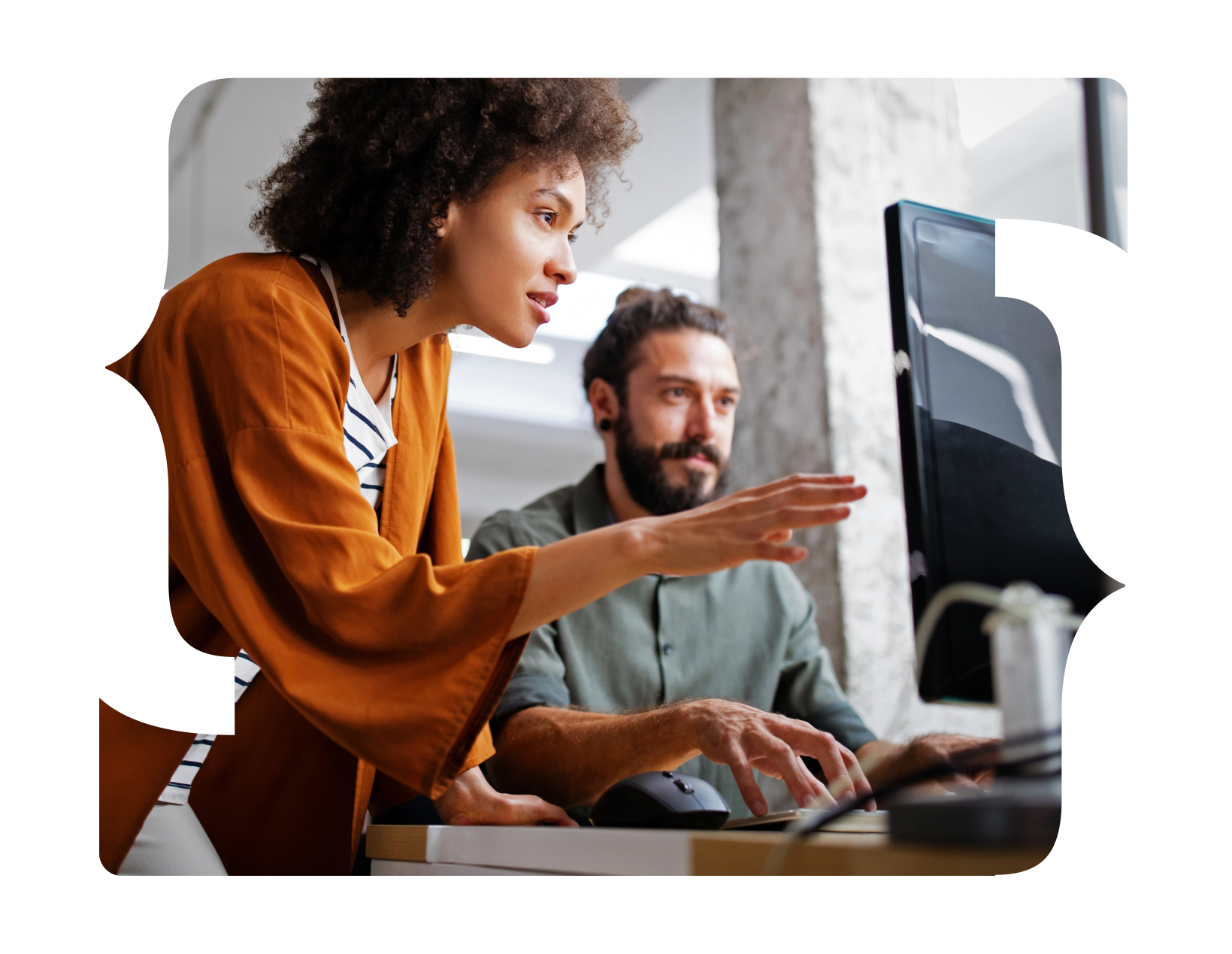 Um homem e uma mulher estão olhando para uma tela de computador.
