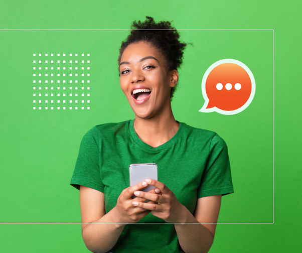 Uma mulher de camisa verde está segurando um celular e sorrindo.