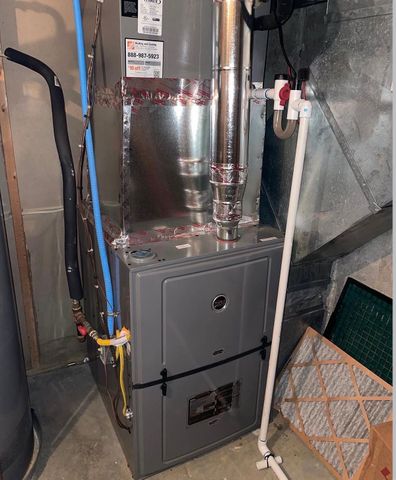 Furnace and HVAC ductwork in a utility closet, with exposed pipes and insulation.