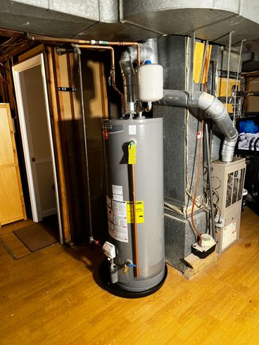 Utility room with water heater, furnace, and ductwork on a wooden floor
