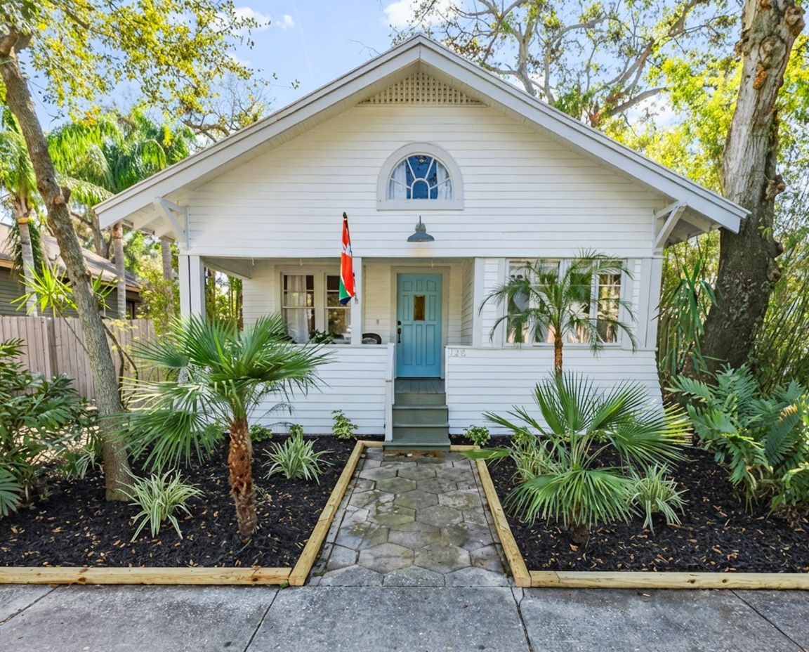 Exterior house painting on a Tampa bungalow with white siding and blue accent door