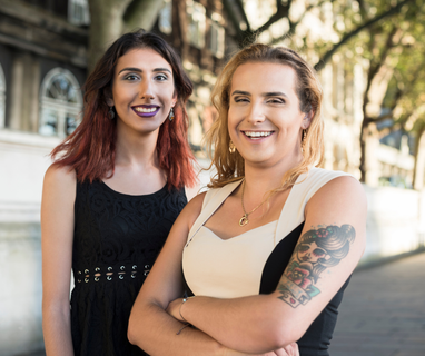 Two women standing next to each other with their arms crossed