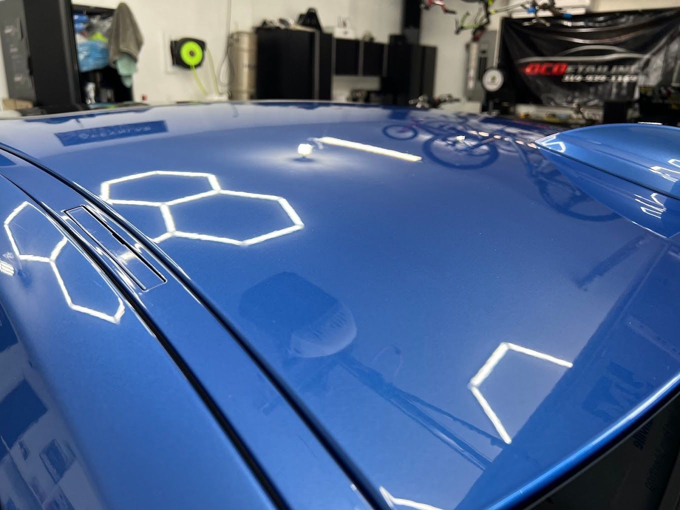 A blue car with a honeycomb pattern on the hood