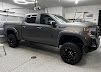 A gray truck is parked in a garage.