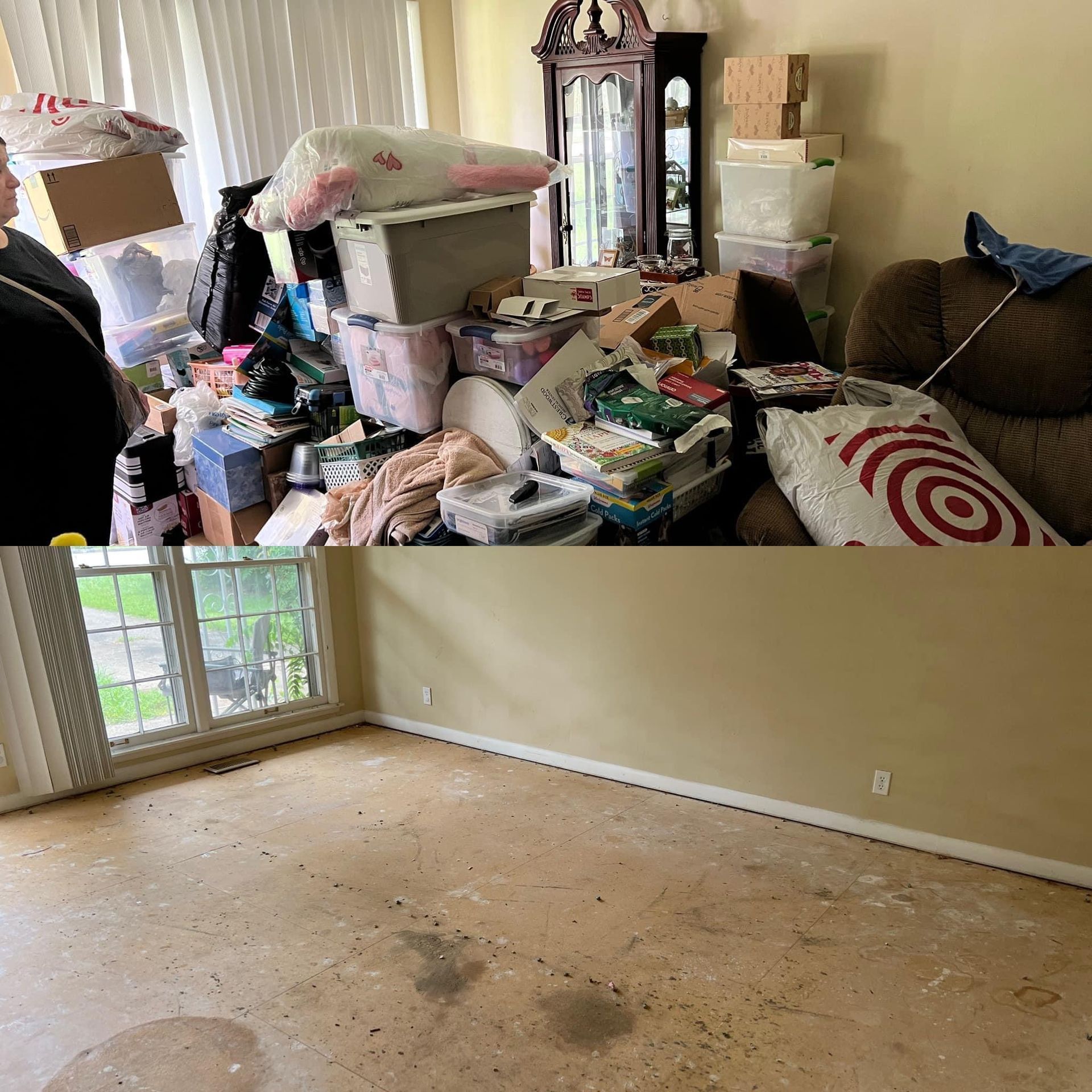 Cluttered room with piles of belongings and a mostly empty beige floor with stains.