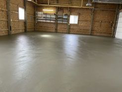 A garage with a concrete floor and wooden walls.