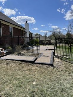A person is working on a concrete walkway in front of a house.