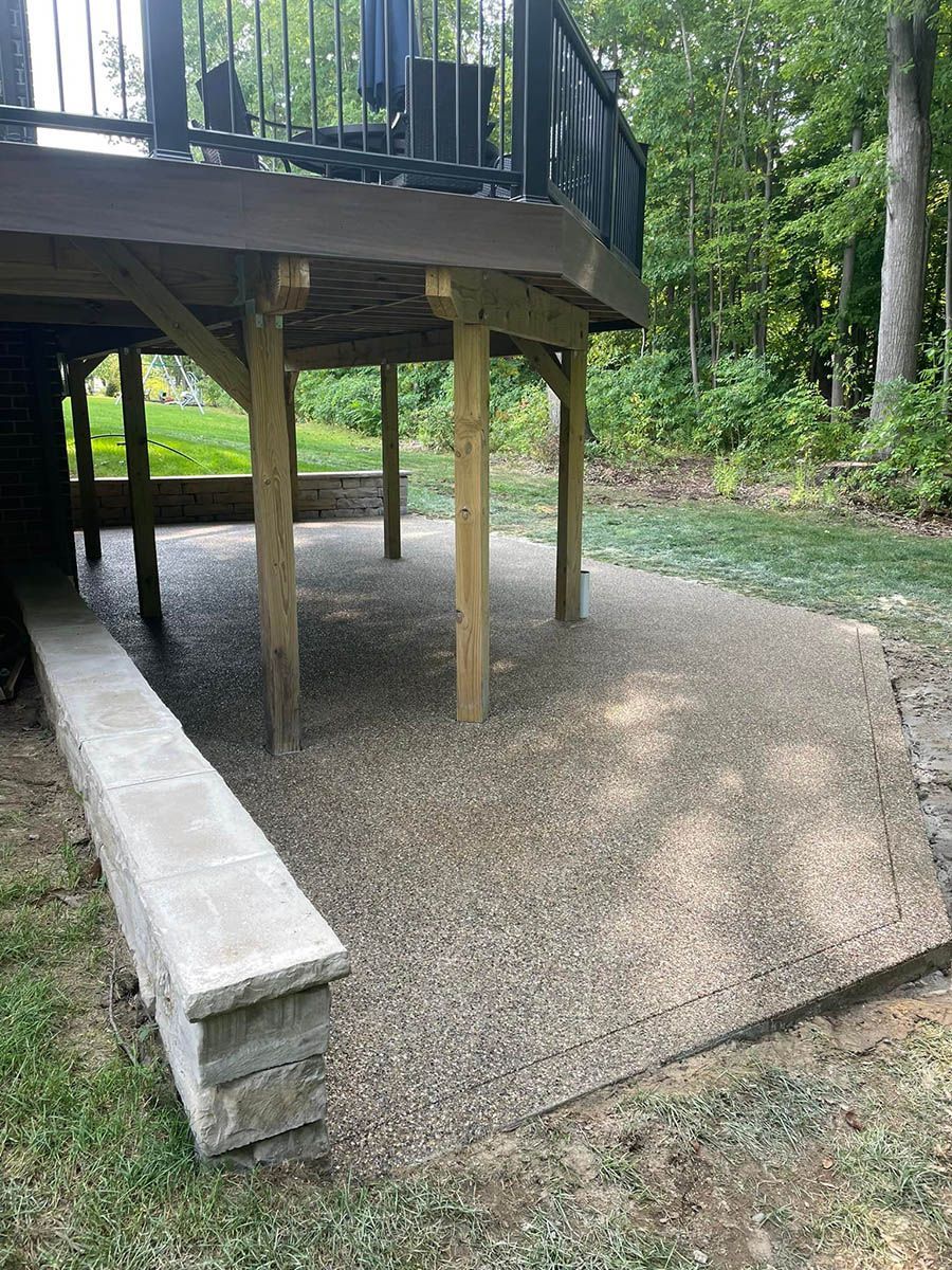 A deck with a bench underneath it in a backyard.