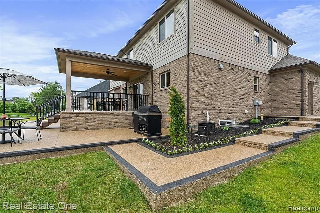A large brick house with a large patio and a covered porch.