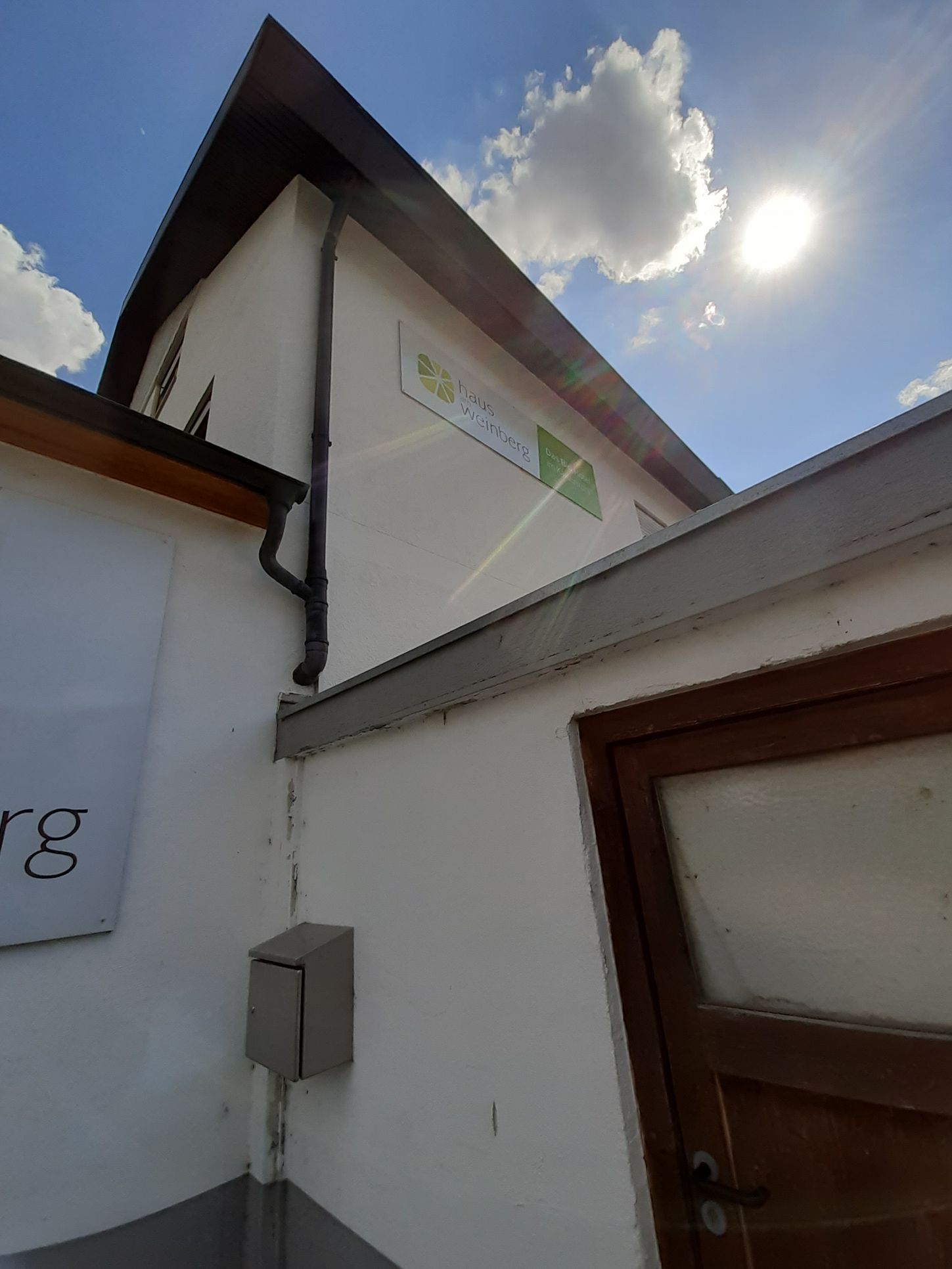 Ein weißes Gebäude mit einem Schild an der Seite, auf dem