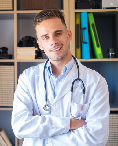 A doctor with a stethoscope around his neck is standing in front of a bookshelf.