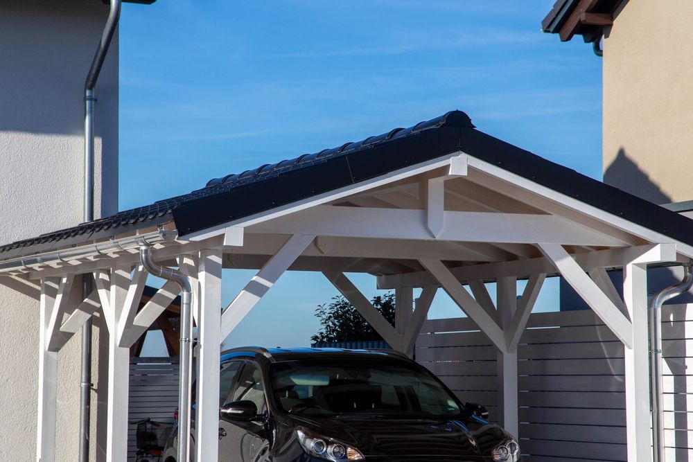 A Car is Parked Under a Wooden Carport in Front of a House — Hunter & Mid Coast Patios In Hamilton, NSW