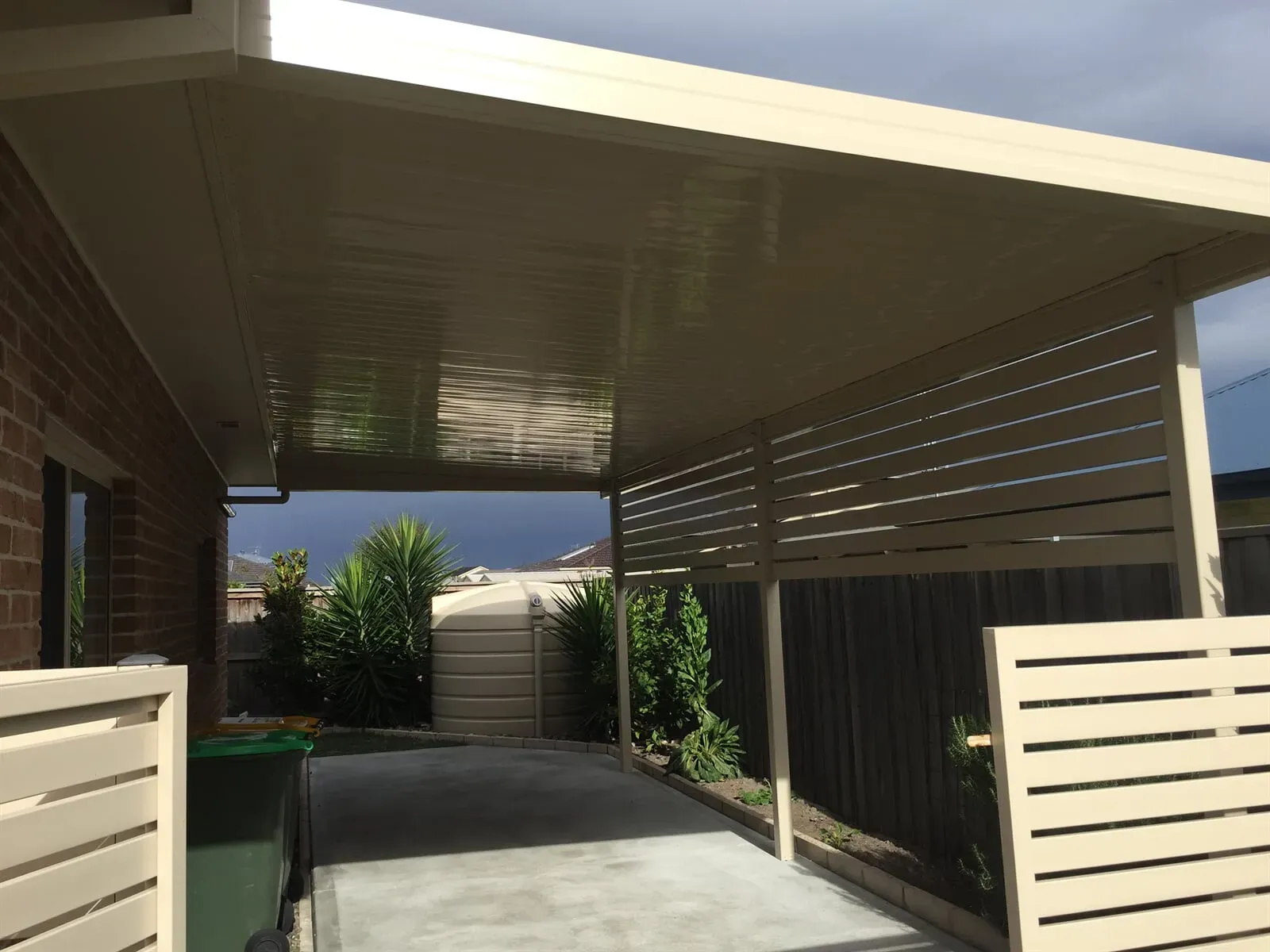 A carport with a fence in front of a brick house. — Hunter & Mid Coast Patios In Newcastle, NSW