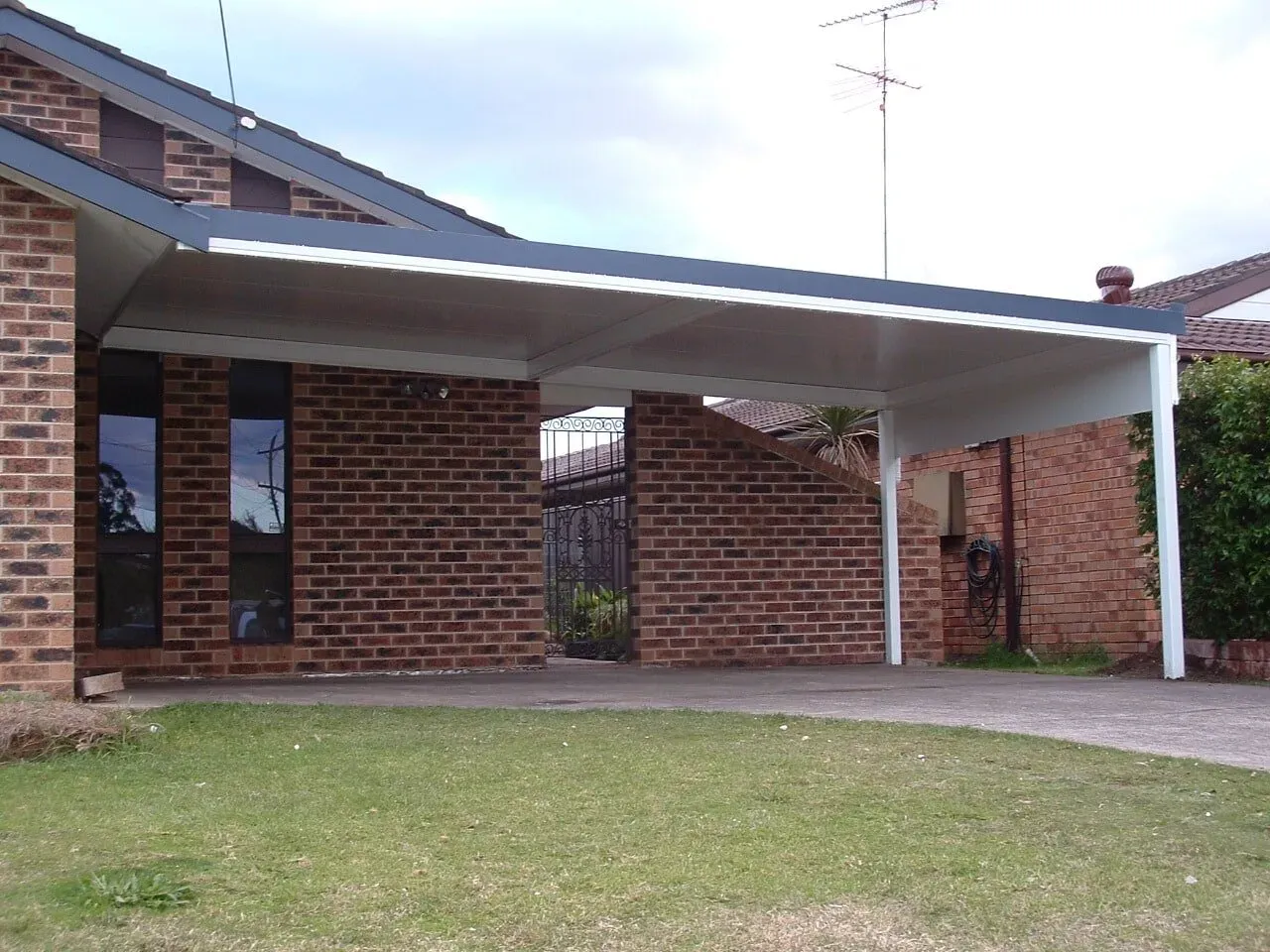 A brick house with a carport in front of it — Hunter & Mid Coast Patios In Port Stephens, NSW