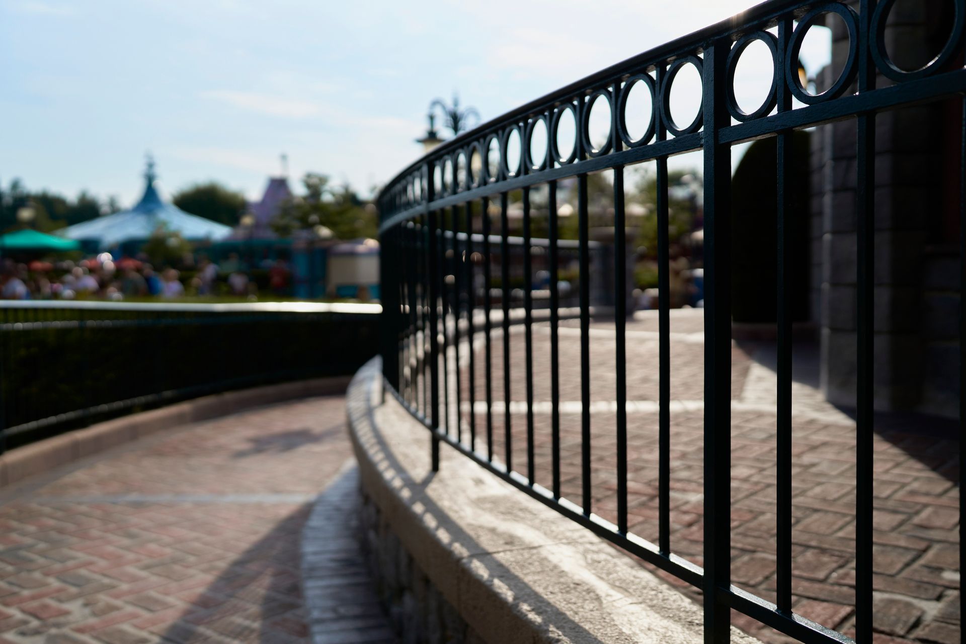 A close up of a wrought iron fence on a brick walkway