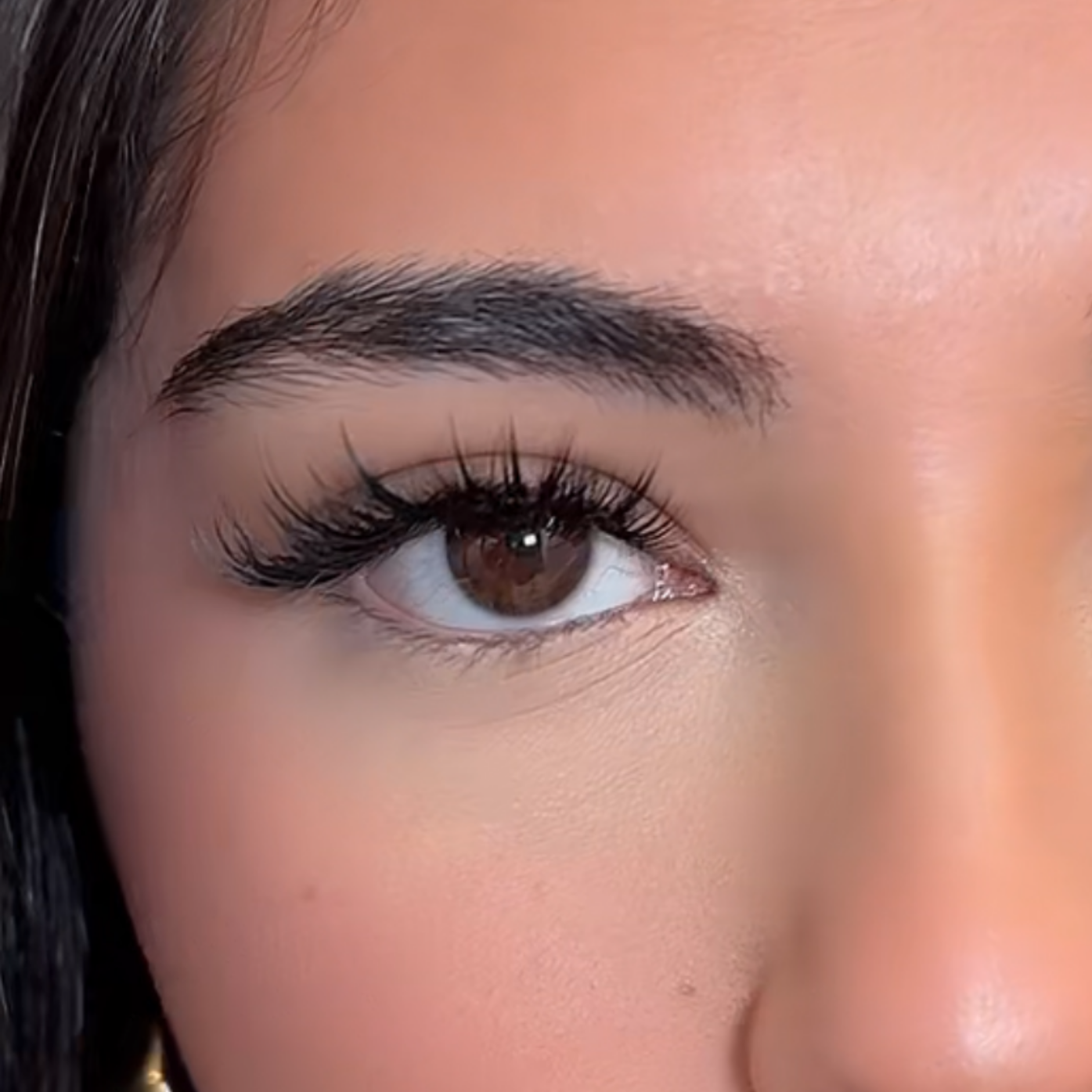 Eine Nahaufnahme des Auges einer Frau mit langen Wimpern.
