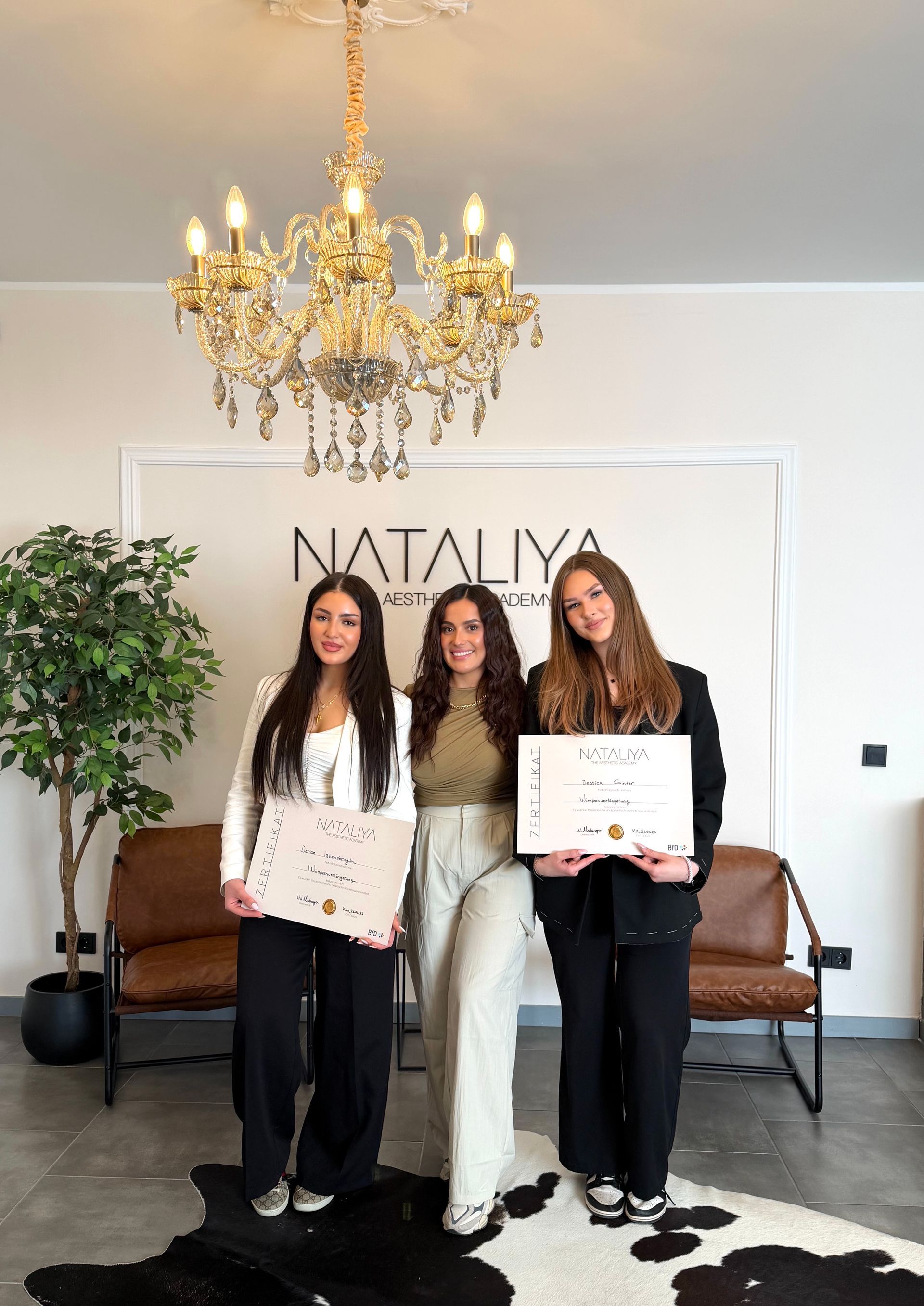Drei Personen posieren mit Urkunde aufgenommen in der NATALIYA Aesthetic Academy für Wimpernschulung in Köln
