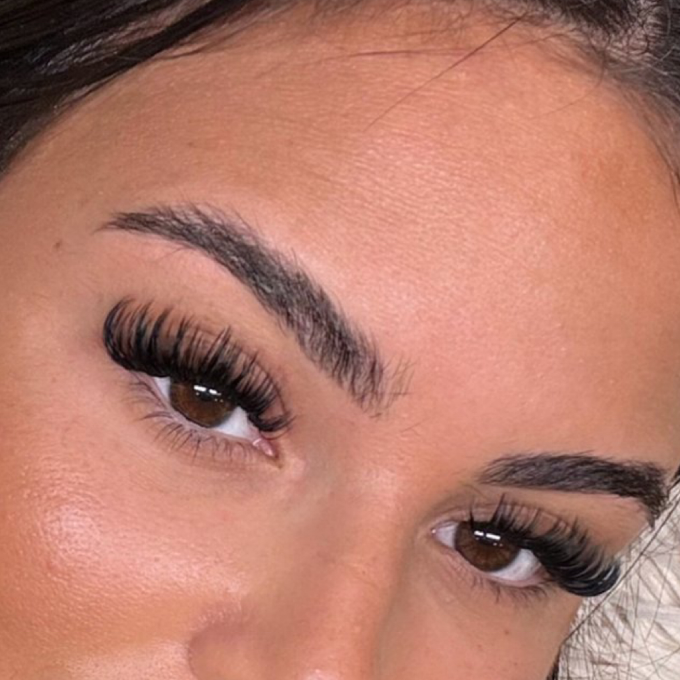 Eine Nahaufnahme des Gesichts einer Frau mit langen Wimpern und Augenbrauen.