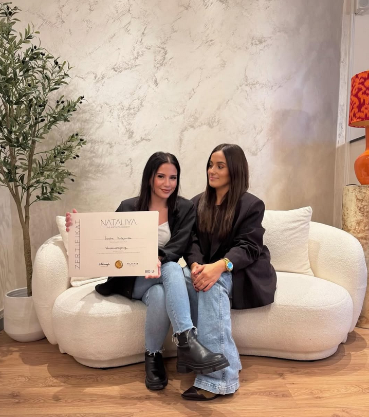 Zwei Frauen halten eine Urkunde in der Hand, als erfolgreicher Teil der professionellen Wimpernschulung bei NATALIYA in Köln.