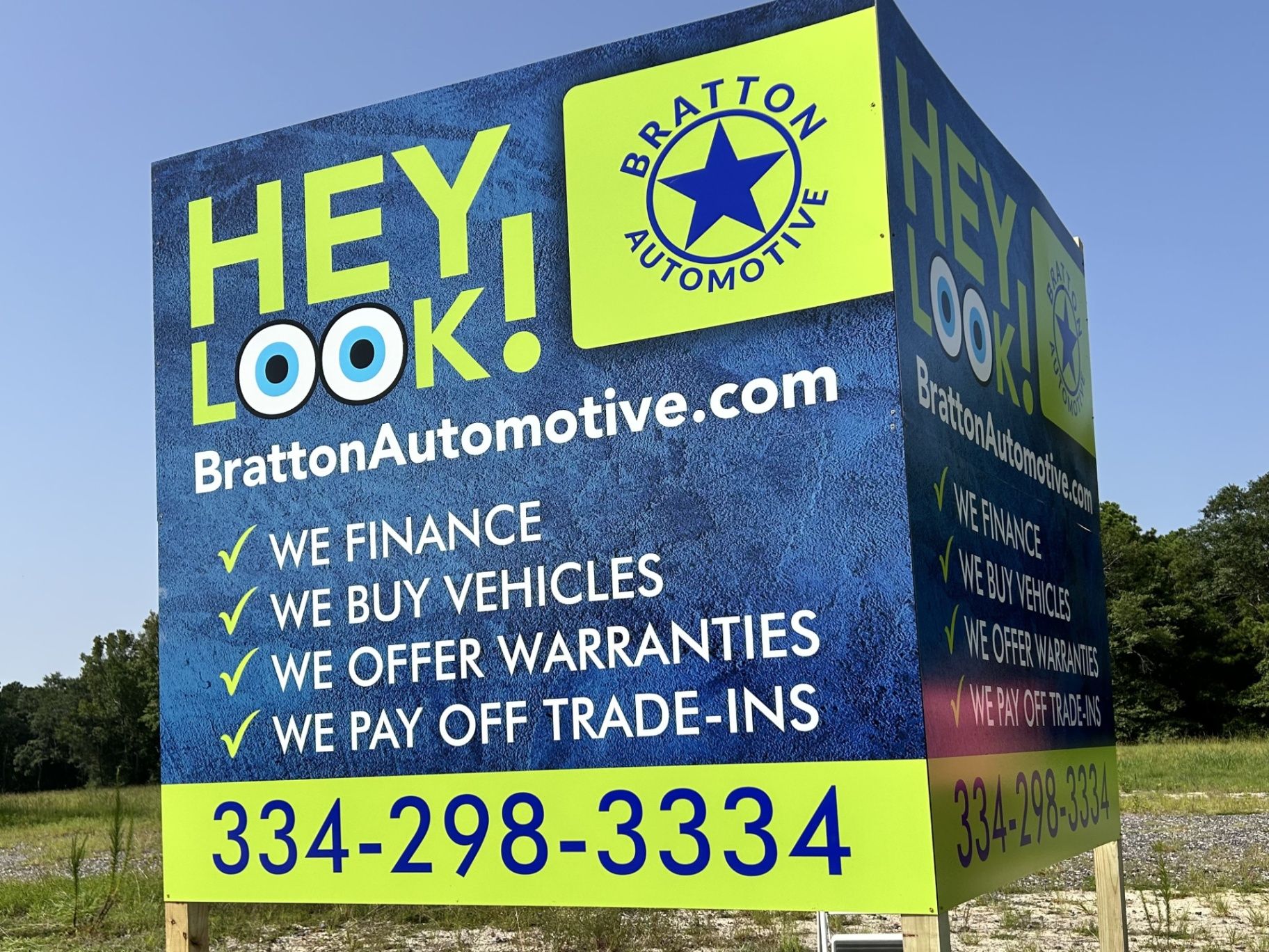 Sign for Bratton Automotive. Blue and green sign with contact info and services offered.