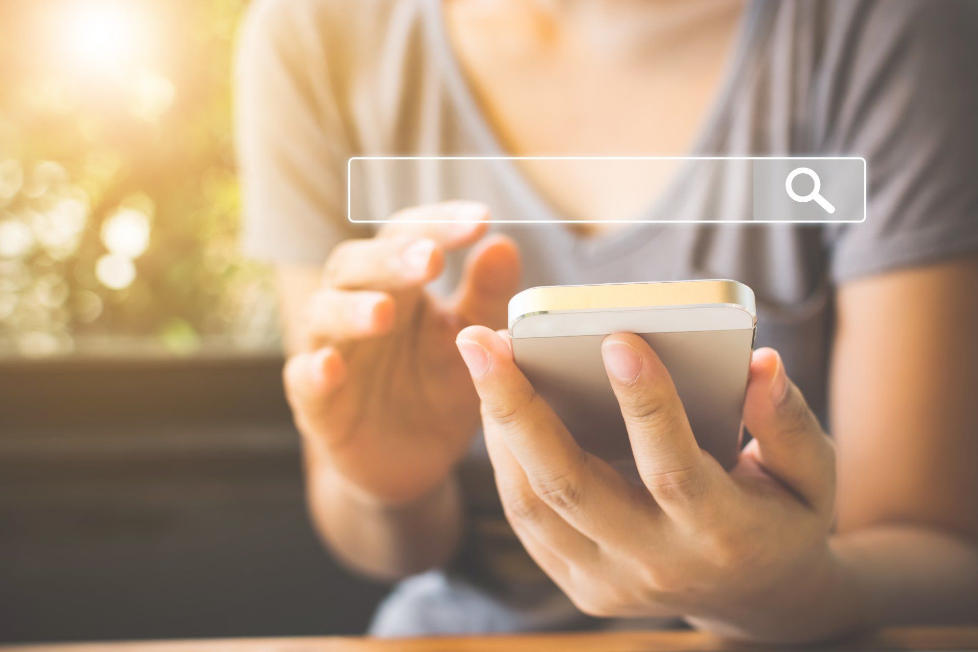 A woman is using a cell phone with a search bar on it.