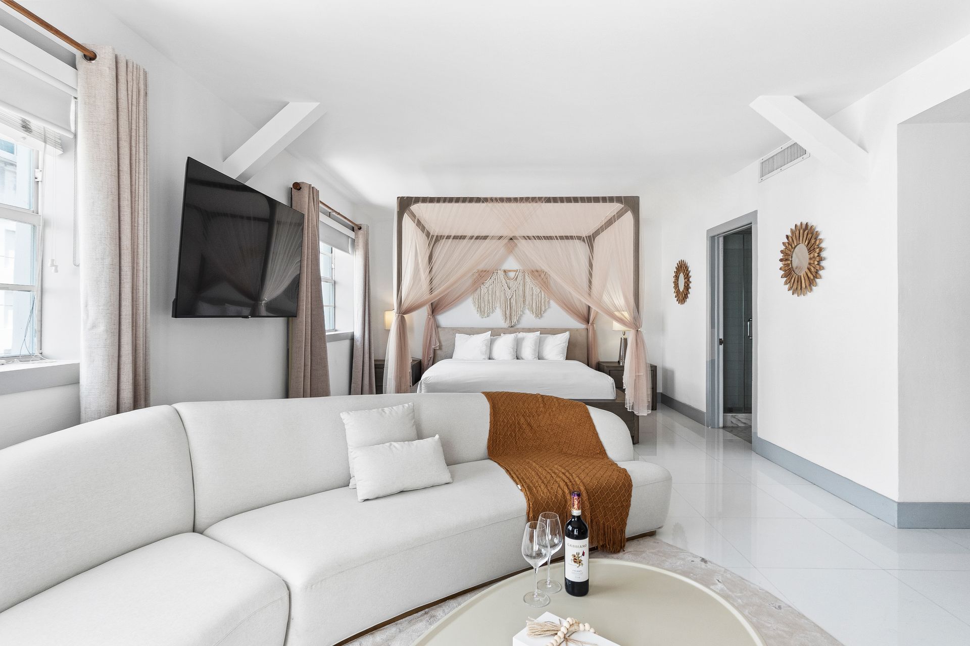 Cozy bedroom with yoga mat, rolled towel, air purifier, and sunlight by a window