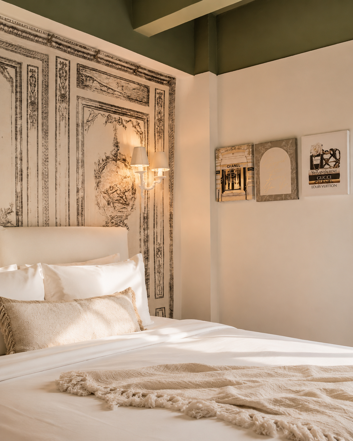 Cozy white bedroom with ornate wall art, soft bedding, and warm natural light