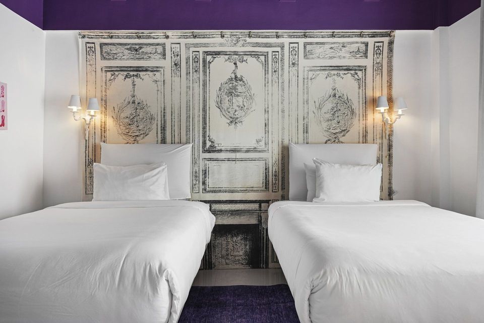 Deluxe room with two beds beneath a painted ceiling