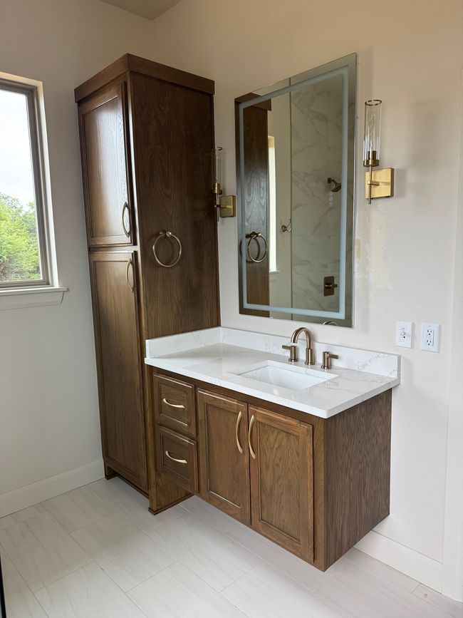 Elegant white bathroom with a soaking tub, wooden vanity, and glass shower.