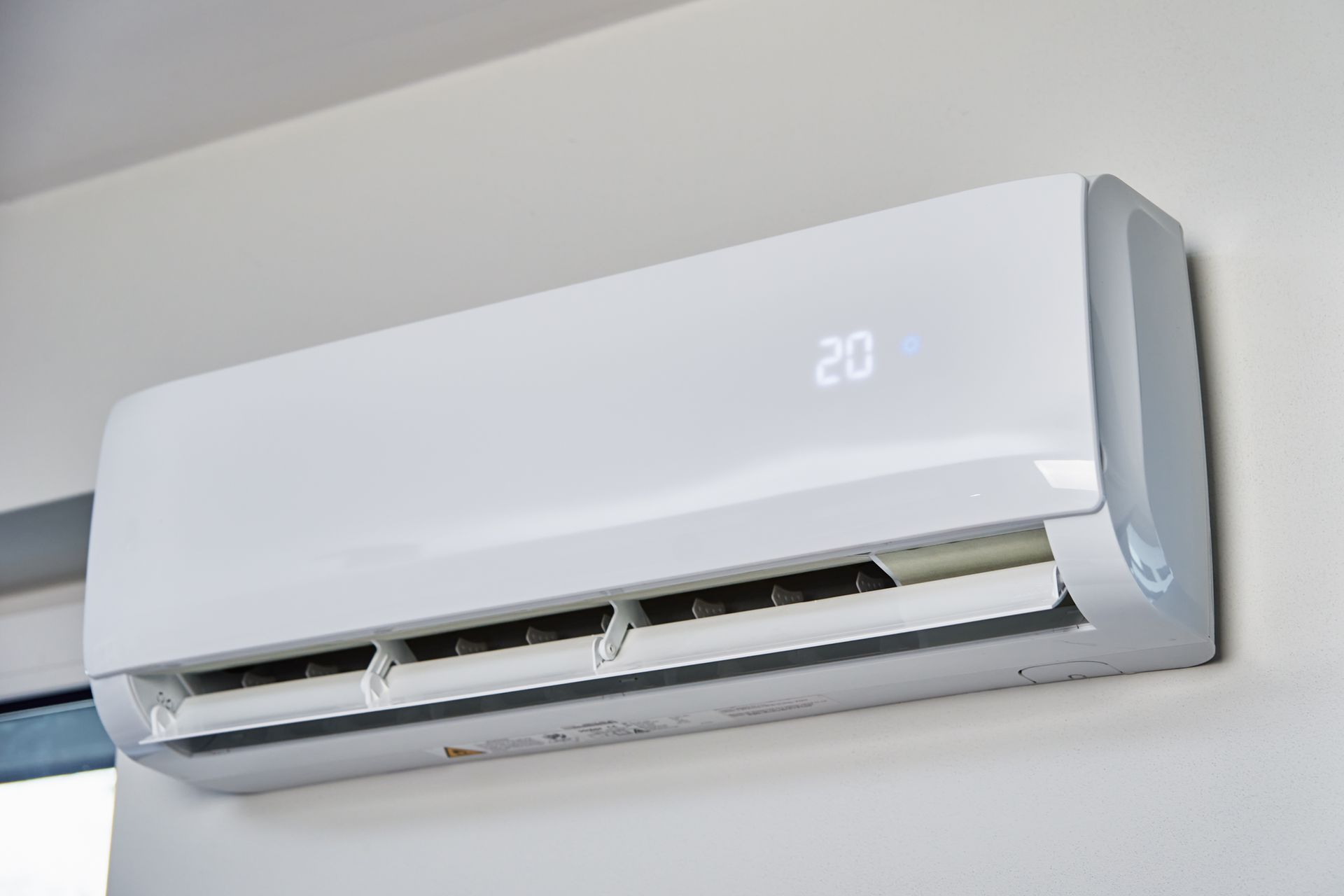 A white, wall-mounted air conditioning unit displaying the number 20 on its front panel.