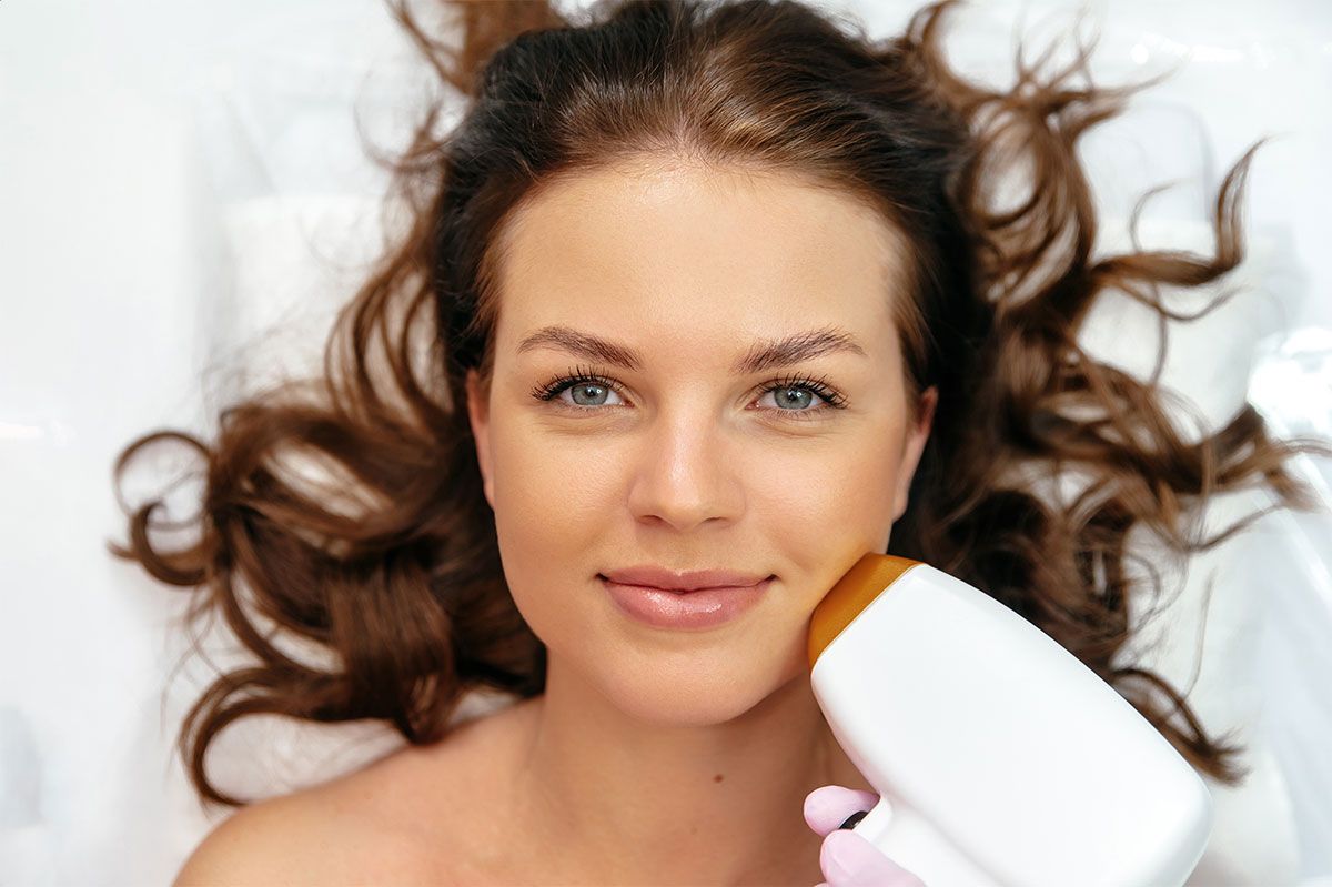 A woman is getting a laser treatment on her face.