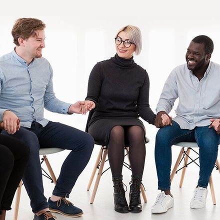 A group of people are sitting in chairs and talking to each other.