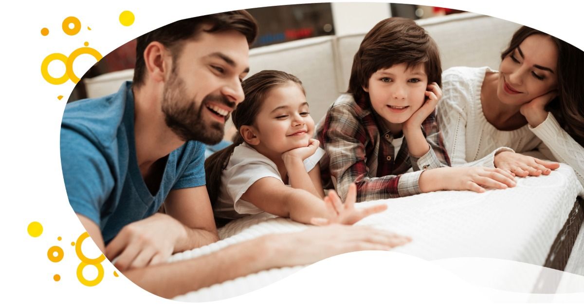 Family smiling and leaning over a white surface, with yellow decorative bubbles on the left.