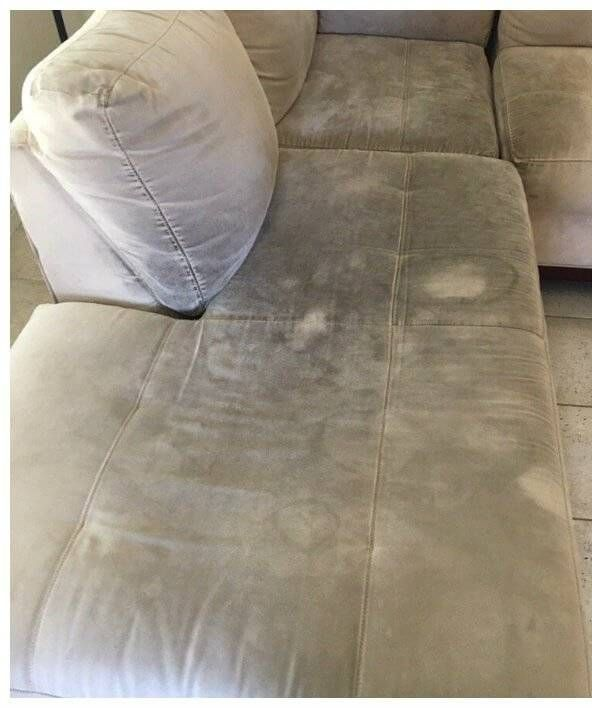 Gray sectional sofa cushion with visible dirty stains and discoloration near the corner pillow.
