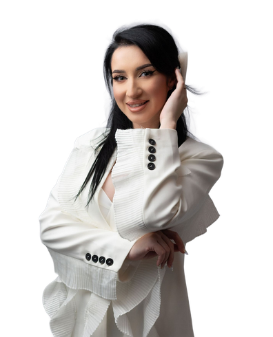 Woman in white blazer smiles, hand in hair, against a light background.