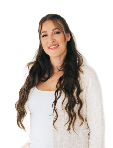Woman in white blazer smiles, hand in hair, against a light background.
