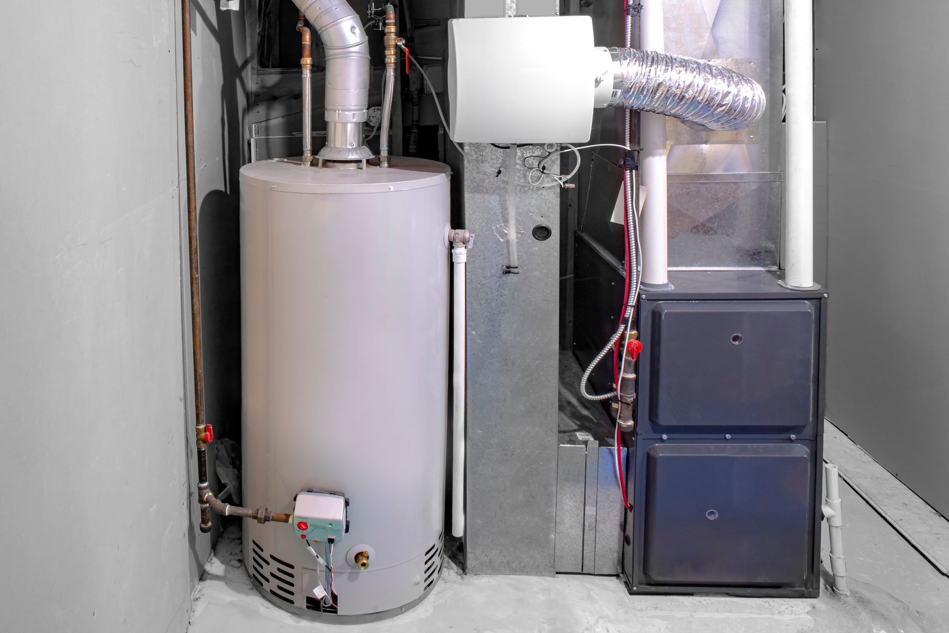 A basement with a water heater, furnace, and ventilation system against gray walls.