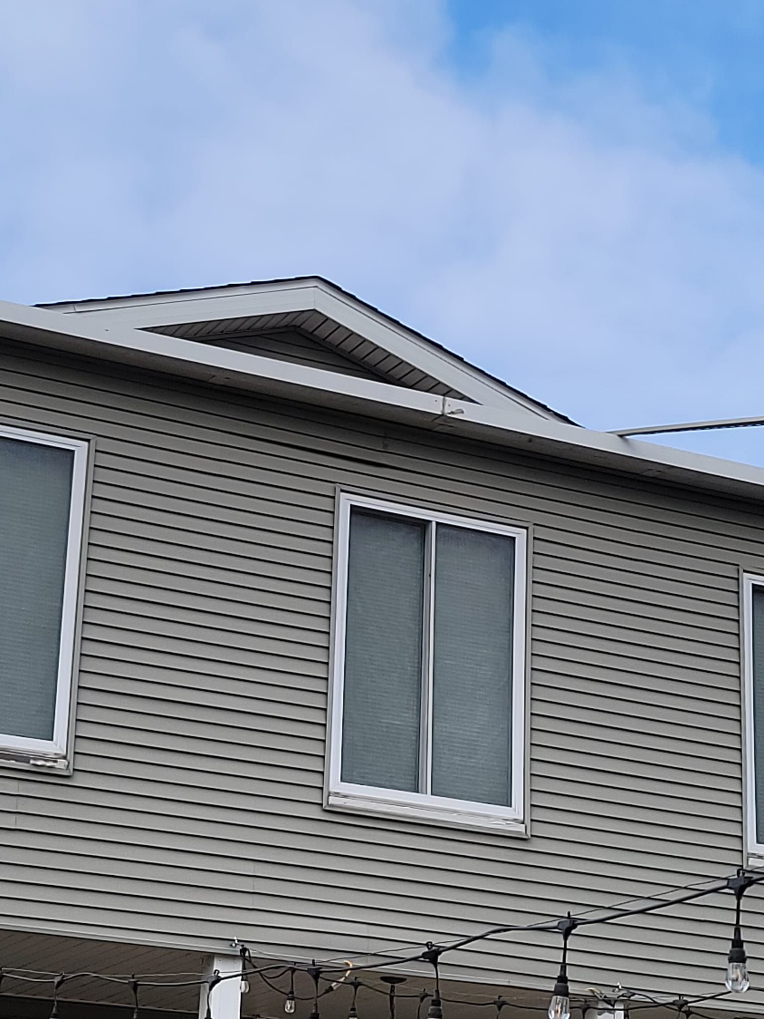 A house with a lot of windows and a blue sky in the background.