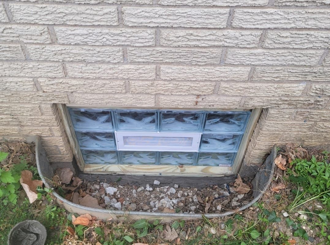 A window in a brick wall with a glass block window.
