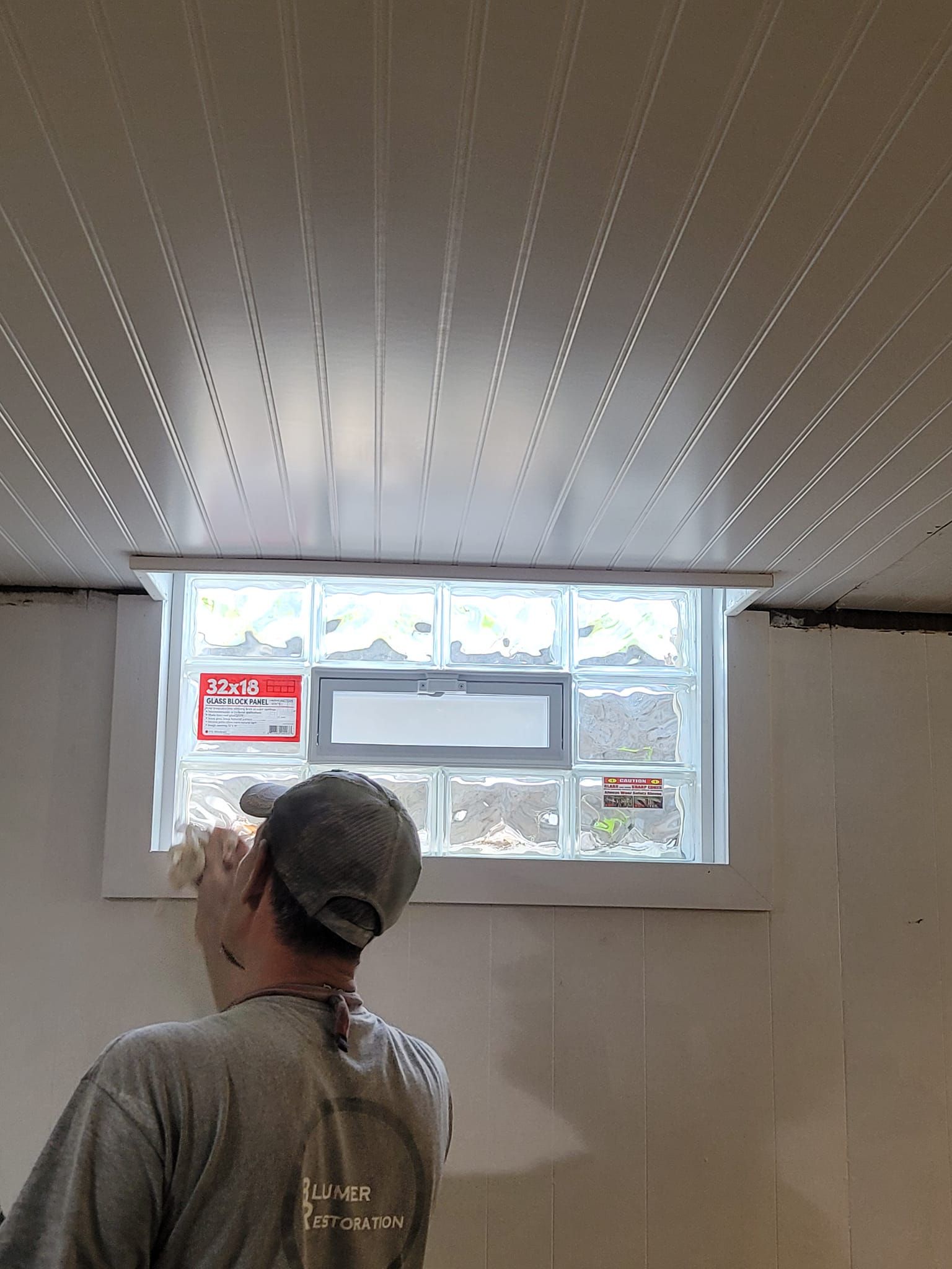 A man is standing in front of a window in a room.