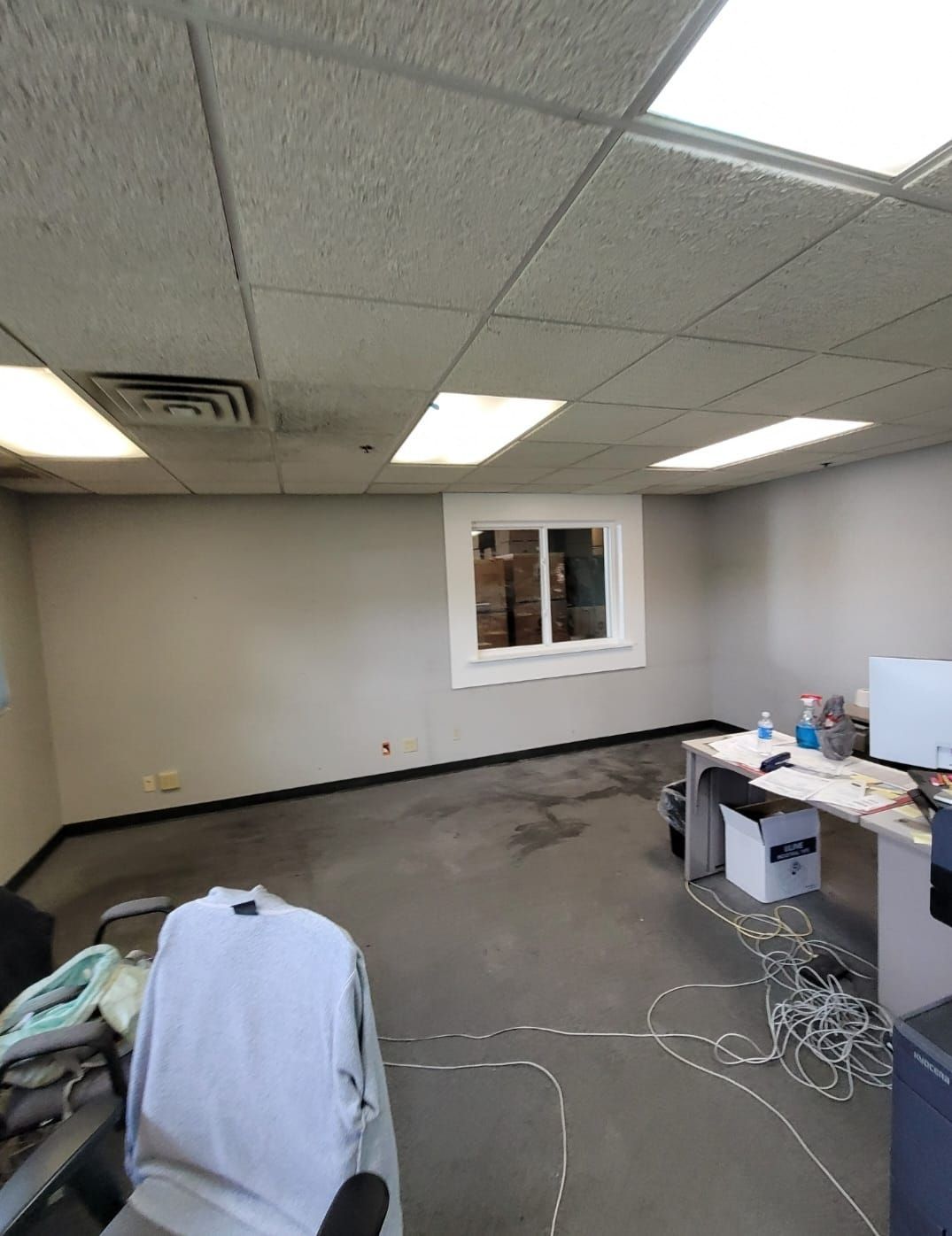 An empty office with a desk , chair , and computer.